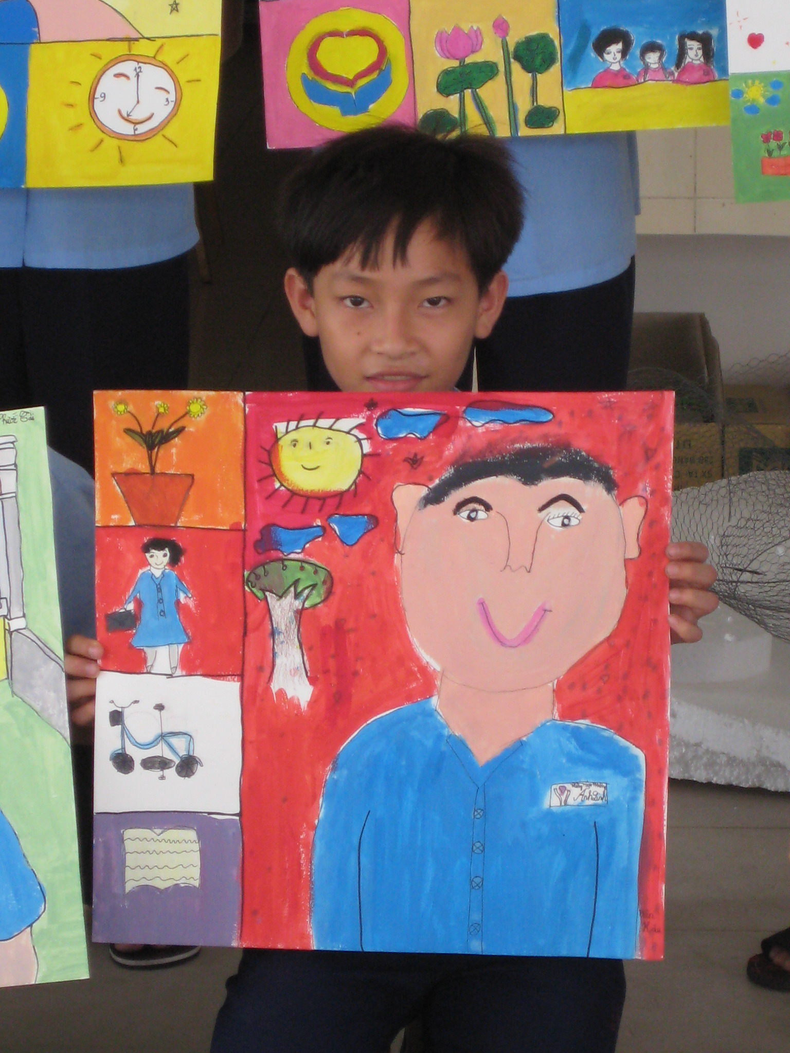 Smiling young impoverished boy with self portrait art. Saigon HCMC Vietnam.